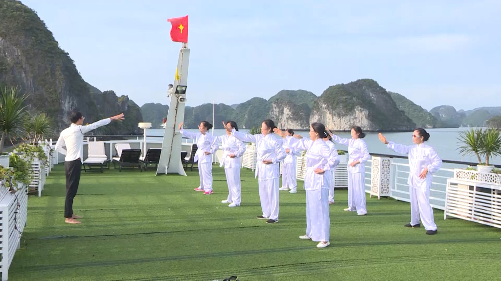 Du khách tập thể dục trên boong tàu trên Vịnh Hạ Long.