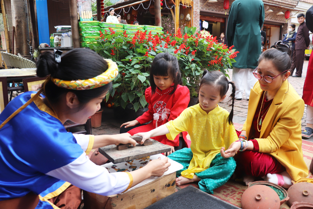 Du khách trải nghiệm in tranh Đông Hồ tại Đình Làng Nương (xã Thượng Yên Công, TP Uông Bí).