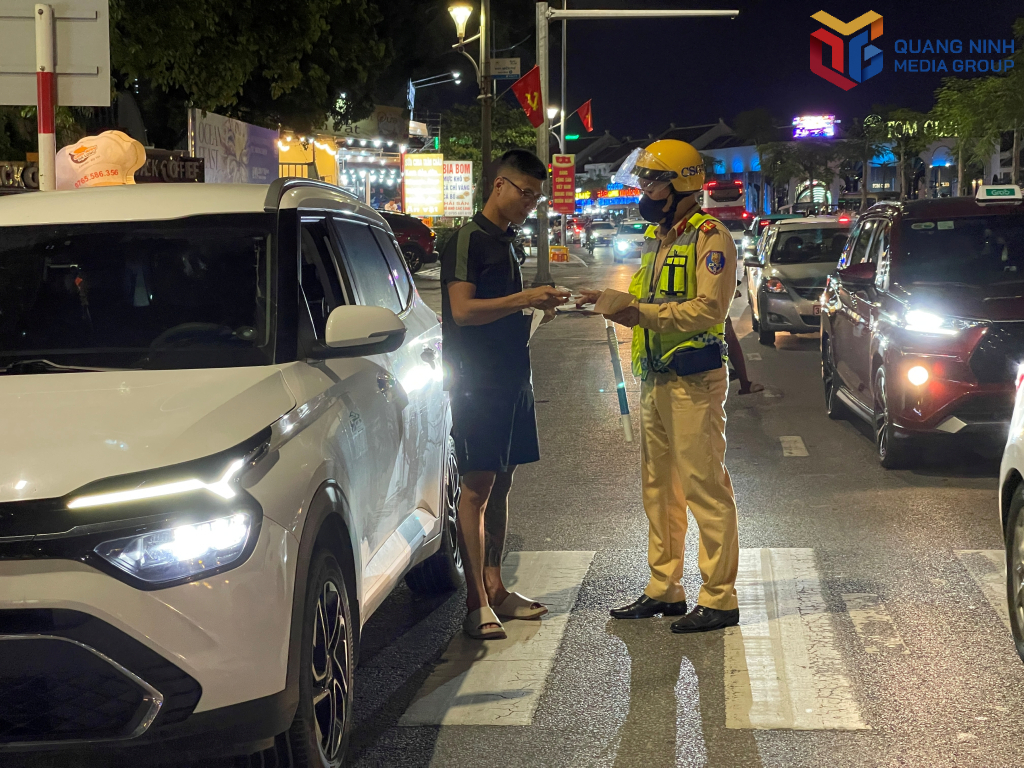 Cán bộ đội CSGT đường bộ số 2, Phòng CSGT (Công an tỉnh) nhắc nhở du khách ngoại tỉnh phải dừng, đỗ xe đúng nơi quy định.